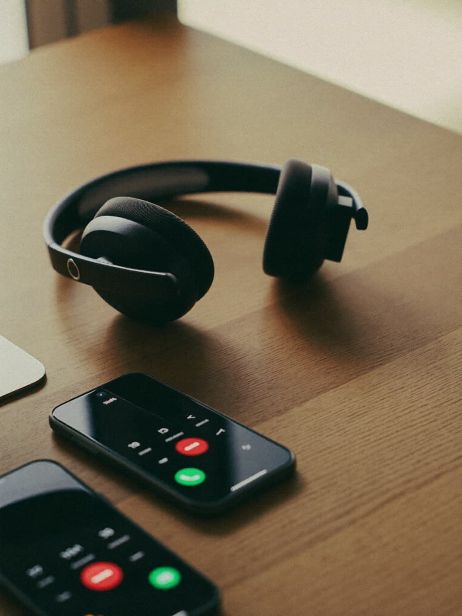 Teléfono descolgado sobre una mesa de despacho — el operador siempre descuelga